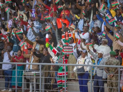 Crowd waving Kenyan flags in a stadium
